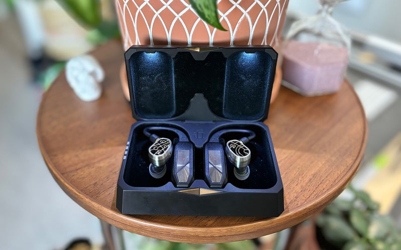 Silver. and gold-plated Campfire Audio Solaris Stellar Horizon hybrid IEMs attached to the iFi GO pods Bluetooth TWS adapters in a black illuminated case